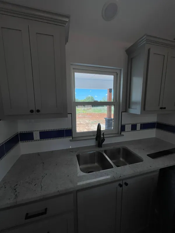 Kitchen sink with blue tile backsplash