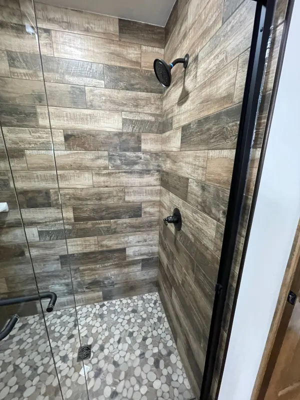 Wood-look tile shower with glass door