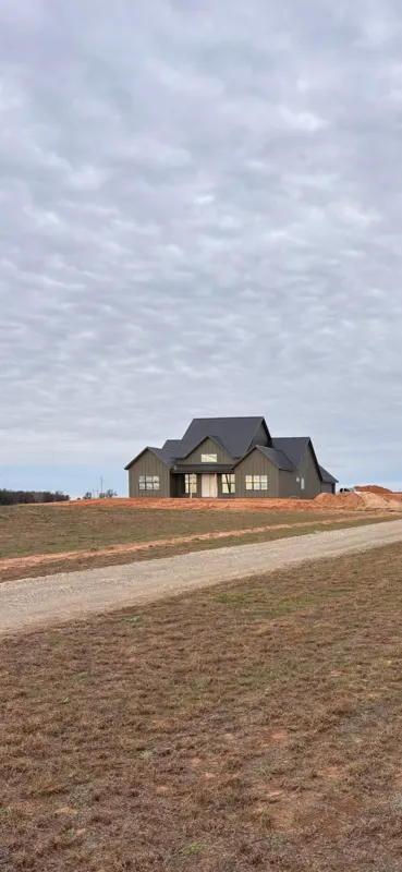Two-story farmhouse on open pasture