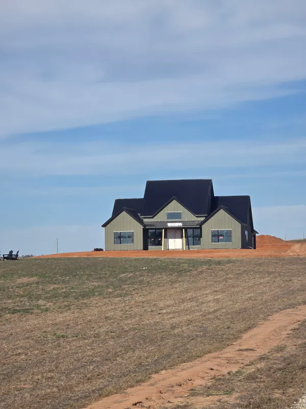 Two-story home with dark roof on a new lot