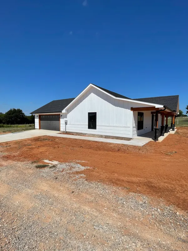 White farmhouse with timber porch and garage