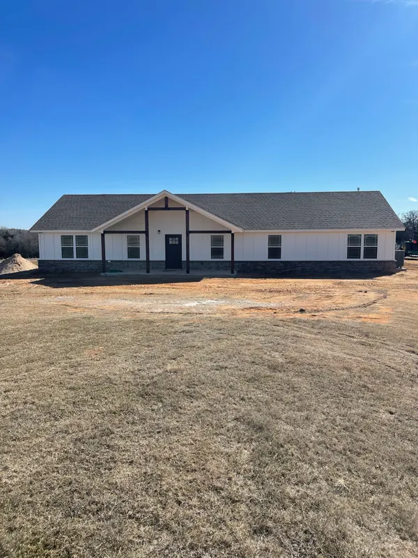 White farmhouse with timber porch on acreage