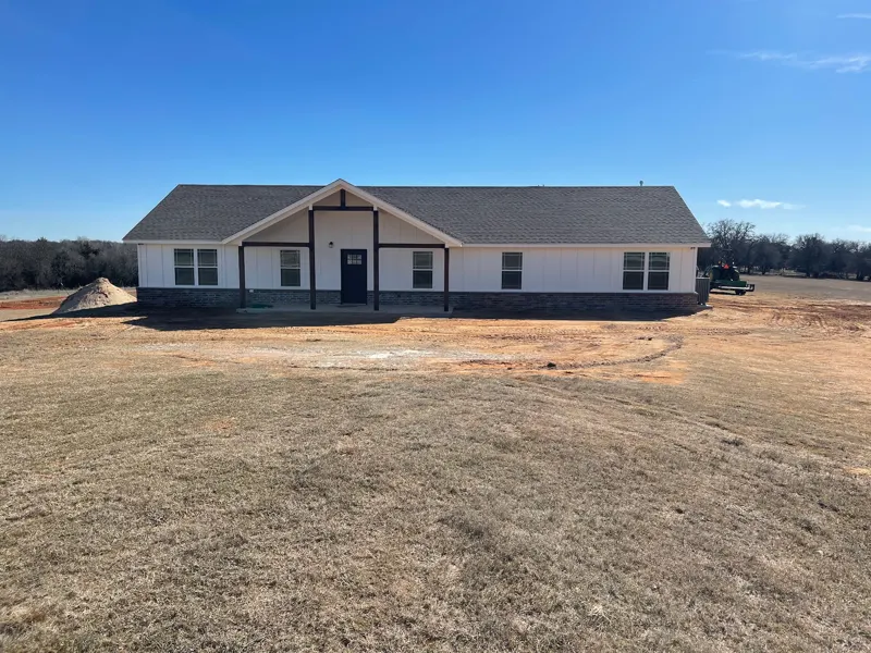 Wide view of a white farmhouse with timber porch