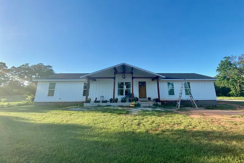 White home with timber porch and green lawn