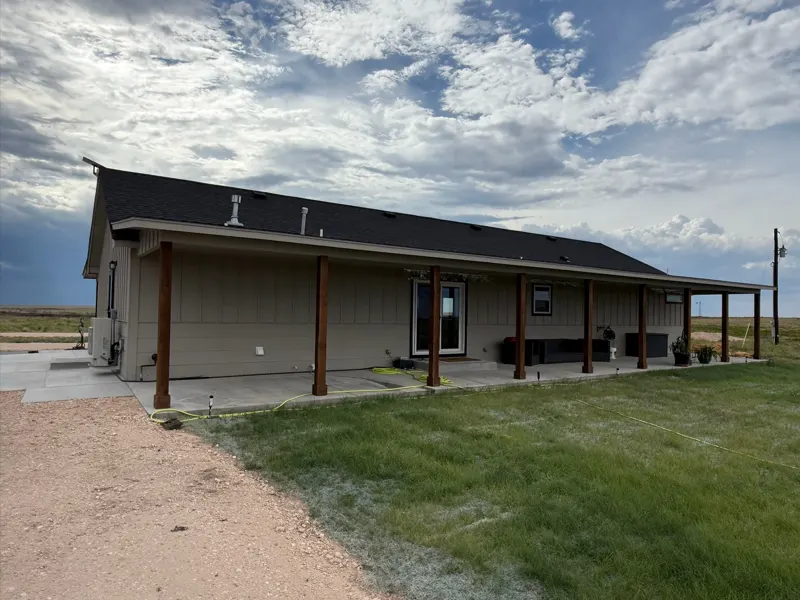 Tan home with porch posts and lawn