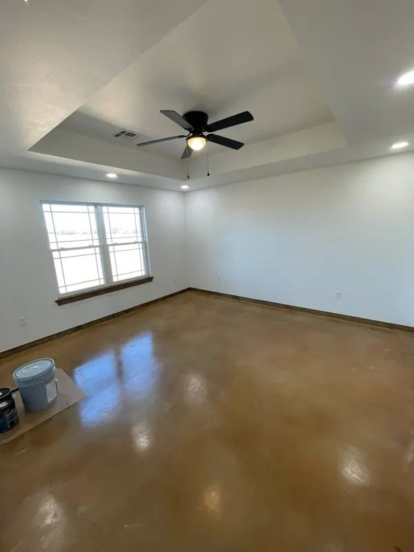 Bedroom with tray ceiling and fan